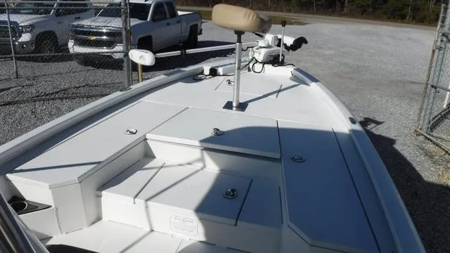 Slide: The Image of 2021 Avid 23 FS boat deck with seating and storage, parked near trucks. - 8