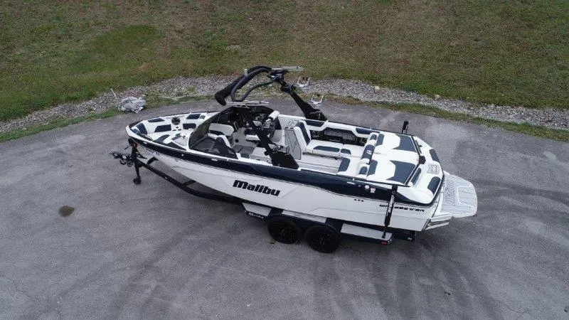 Slide: The Image of 2021 Malibu 25 LSV boat on trailer, parked on pavement. - 10
