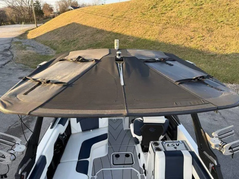Slide: The Image of 2021 Malibu 25 LSV boat with covered seating area and sleek design. - 14