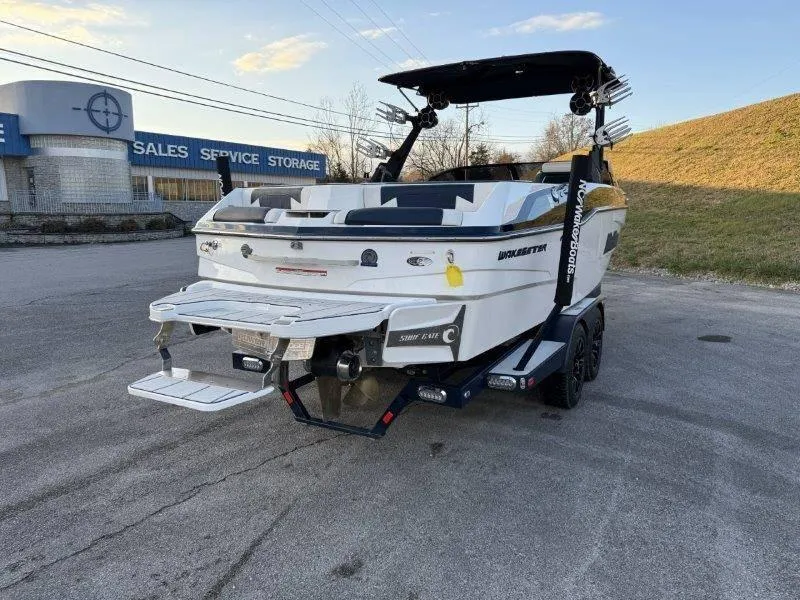 Slide: The Image of 2021 Malibu 25 LSV boat on trailer, parked near sales and service center. - 16