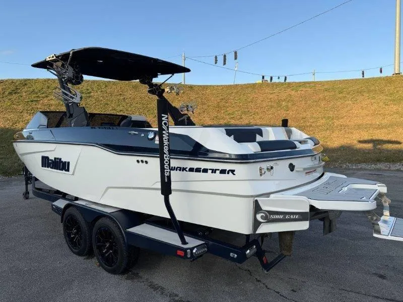 Slide: The Image of 2021 Malibu 25 LSV boat on trailer, featuring sleek design and wakeboard tower. - 25