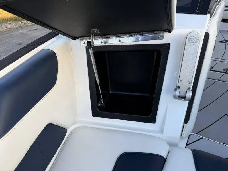 Slide: The Image of 2021 Malibu 25 LSV boat interior storage compartment with open lid. - 30