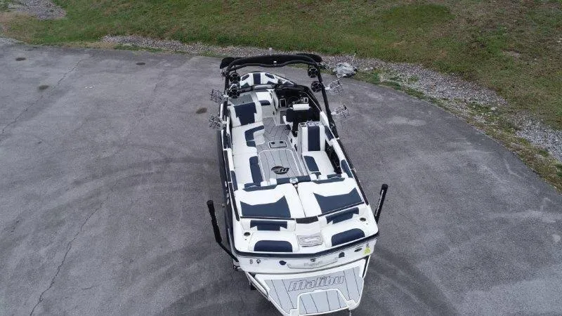 Slide: The Image of 2021 Malibu 25 LSV boat, aerial view, parked on concrete near grass. - 4