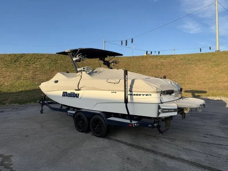 Slide: The Image of 2021 Malibu 25 LSV boat on trailer, covered, parked outdoors. - 49