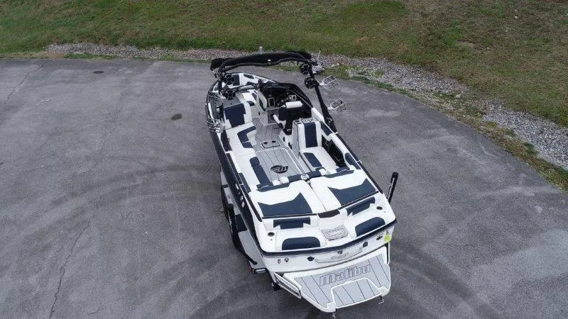 Slide: The Image of 2021 Malibu 25 LSV boat, aerial view, parked on concrete near grass. - 5