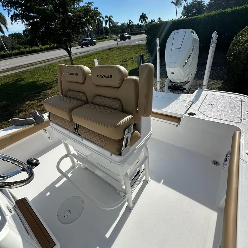 Slide: The Image of 2025 Caymas 28 HB boat interior with cushioned seating and Mercury outboard motor. - 11
