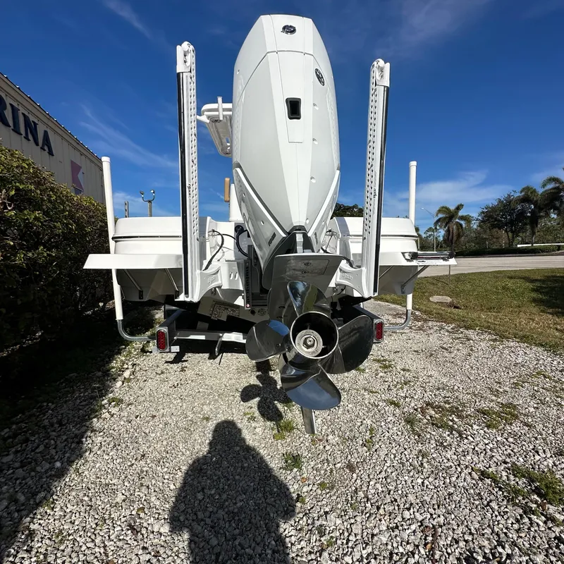 Slide: The Image of 2025 Caymas 28 HB boat with powerful outboard motor, parked on gravel. - 4