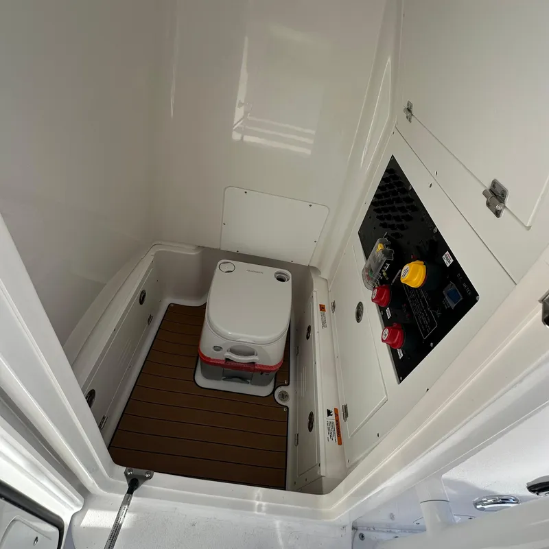 Slide: The Image of 2025 Caymas 28 HB boat interior with portable toilet and control panel. - 9