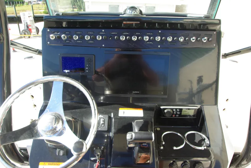 Slide: The Image of 2018 Wellcraft 222 Scarab Offshore boat dashboard with steering wheel and control panel. - 15