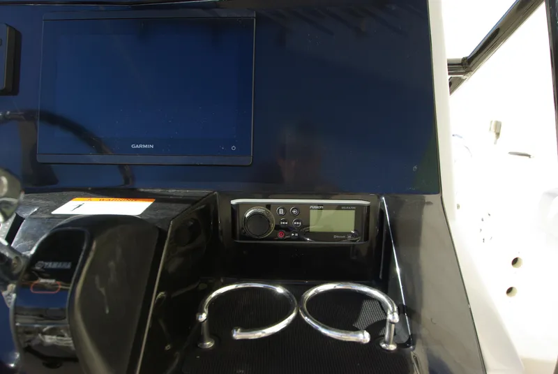 Slide: The Image of 2018 Wellcraft 222 Scarab Offshore dashboard with Garmin display and radio controls. - 18