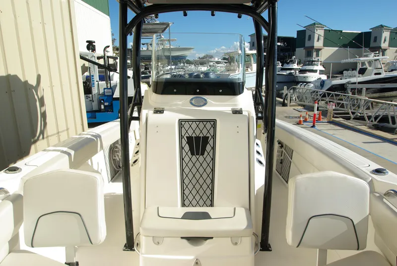 Slide: The Image of 2018 Wellcraft 222 Scarab Offshore boat interior at marina, featuring seating and console. - 24