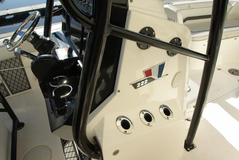 Slide: The Image of 2018 Wellcraft 222 Scarab Offshore boat interior with steering console and cup holders. - 11