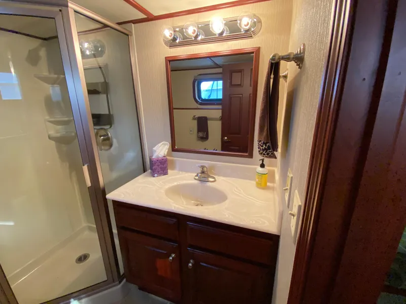 Slide: The Image of Luxurious 2005 Skipperliner Millenium bathroom with shower, vanity, and wooden cabinetry. - 23