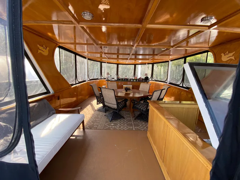 Slide: The Image of 2005 Skipperliner Millenium boat with enclosed cabin, surrounded by lush green trees. - 40