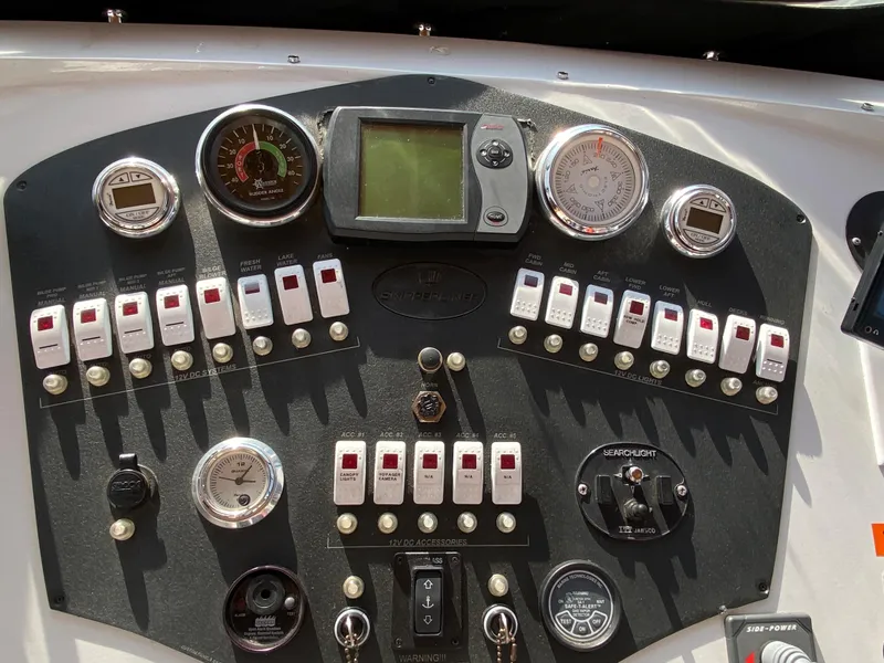 Slide: The Image of Control panel of a 2005 Skipperliner Millenium boat with steering wheel and navigation equipment. - 46