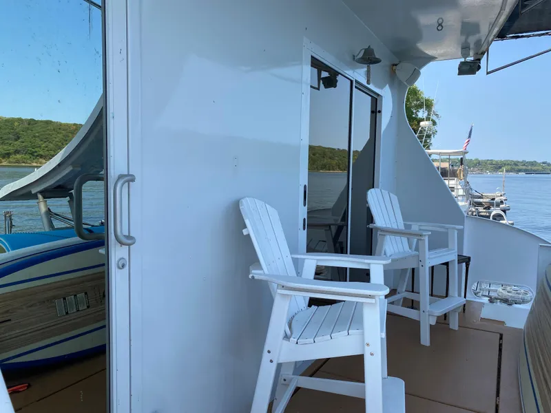 Slide: The Image of 2005 Skipperliner Millenium boat with slide, docked on a serene lake with lush green shoreline. - 6