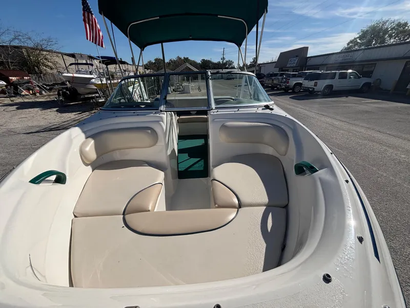 Slide: The Image of 1998 Sea Ray 180 Bow Rider boat with spacious seating and canopy in a sunny marina. - 14