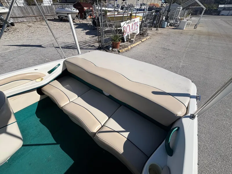Slide: The Image of 1998 Sea Ray 180 Bow Rider interior with beige seating and green carpet. - 15
