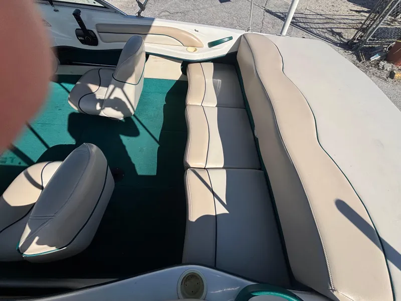 Slide: The Image of 1998 Sea Ray 180 Bow Rider interior with beige seats and green carpet. - 16
