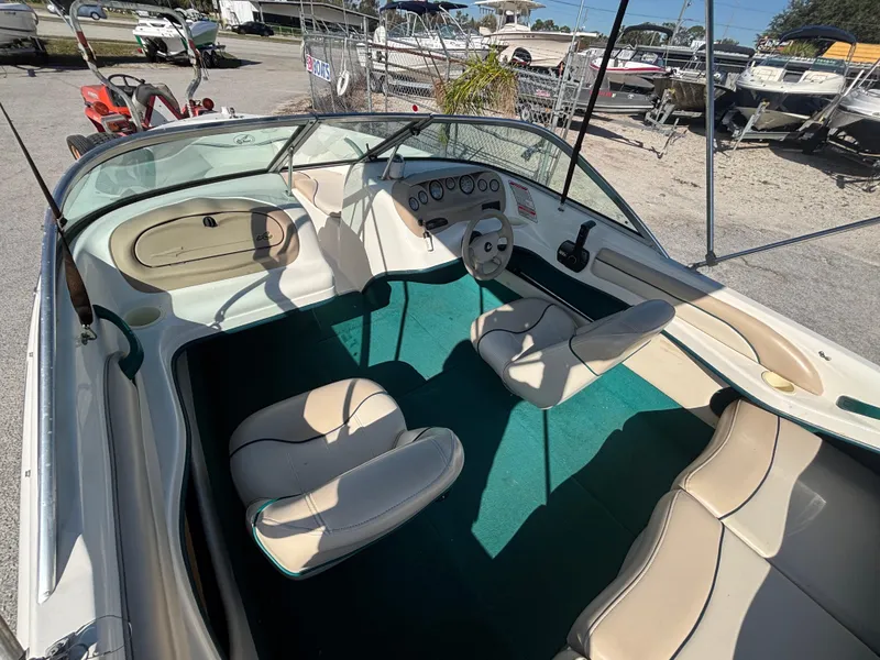 Slide: The Image of 1998 Sea Ray 180 Bow Rider interior with beige seats and green carpet. - 18