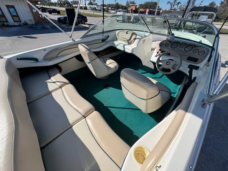 Slide: The Image of 1998 Sea Ray 180 Bow Rider interior with beige seats and green carpet. - 20