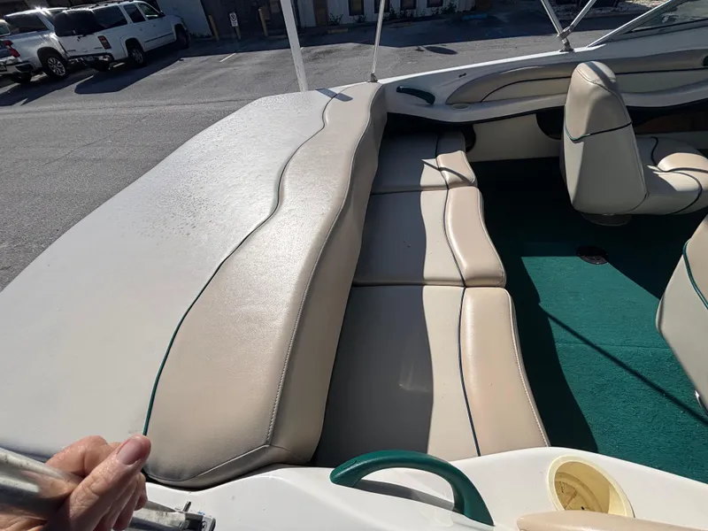 Slide: The Image of 1998 Sea Ray 180 Bow Rider interior with beige seating and green carpet. - 23