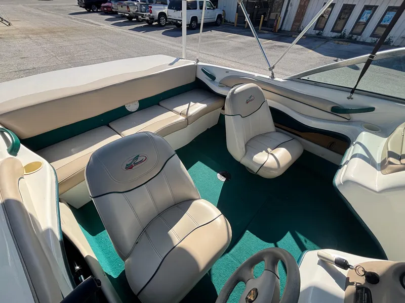 Slide: The Image of 1998 Sea Ray 180 Bow Rider interior with beige seats and green carpet. - 24