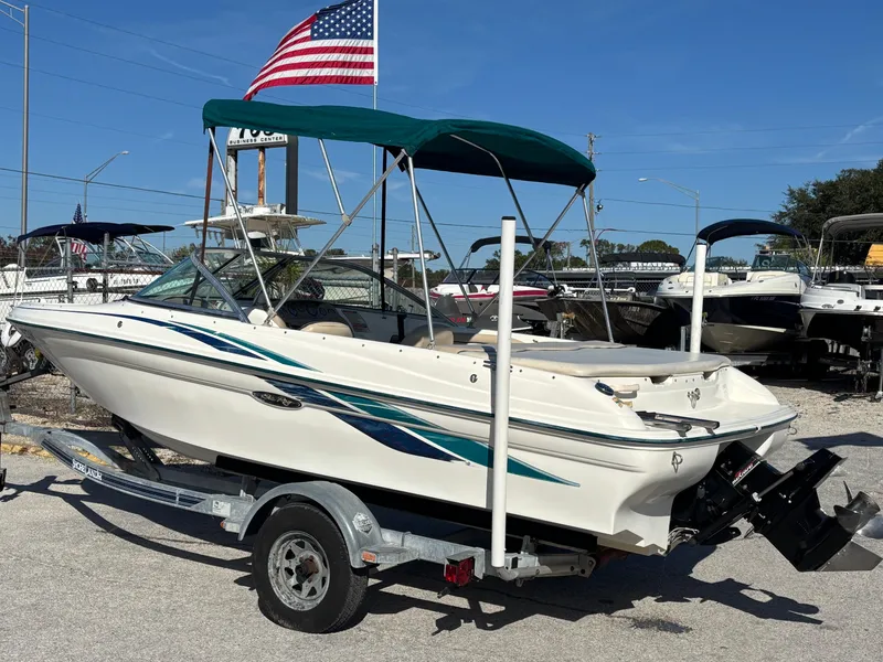 Slide: The Image of 1998 Sea Ray 180 Bow Rider boat on trailer with American flag in background. - 3