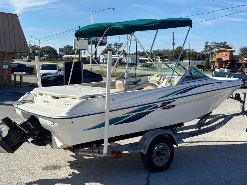 Slide: The Image of 1998 Sea Ray 180 Bow Rider boat on trailer with green canopy. - 7