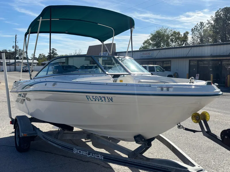 Slide: The Image of 1998 Sea Ray 180 Bow Rider boat on trailer with green canopy. - 9