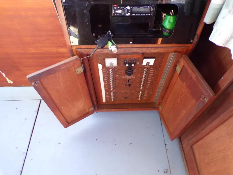 Slide: The Image of Electrical panel inside a 1986 Jersey Dawn 40 boat with open wooden cabinet doors. - 10