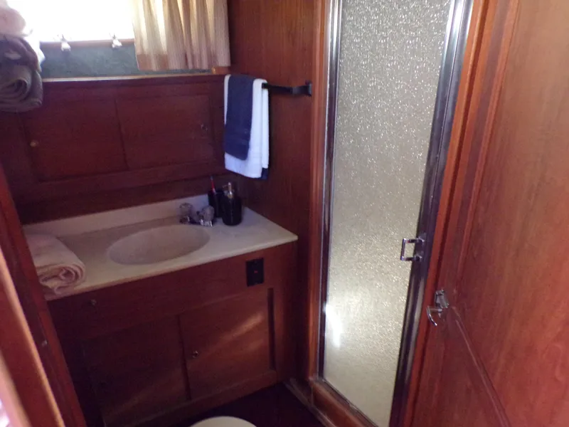 Slide: The Image of 1986 Jersey Dawn 40 yacht bathroom with wooden cabinetry, sink, and shower. - 15