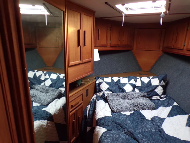 Slide: The Image of Cozy cabin interior of 1986 Jersey Dawn 40 with quilted bedding and wooden cabinetry. - 18