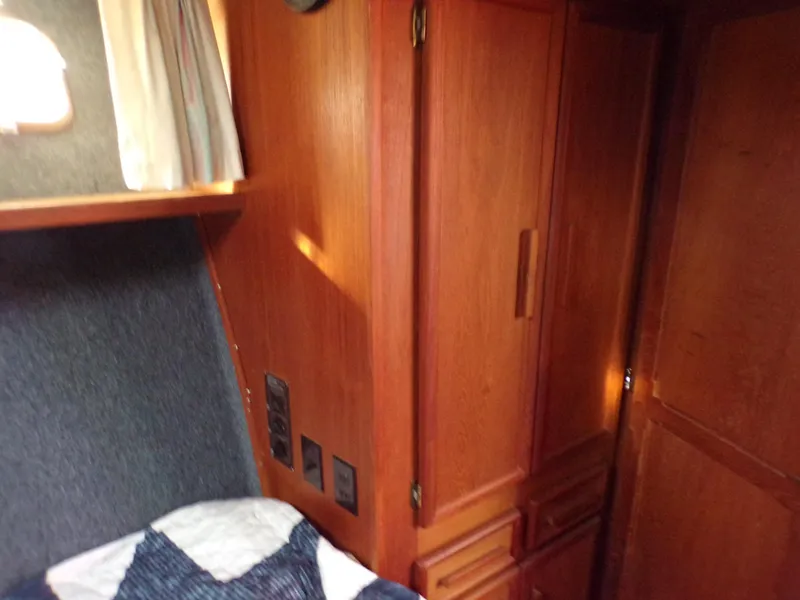 Slide: The Image of Interior of 1986 Jersey Dawn 40 boat with wooden cabinetry and cozy sleeping area. - 19