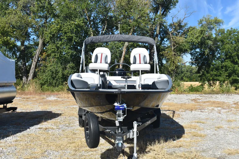 Slide: The Image of 2025 Lowe SD224 Sport Deck boat on trailer, parked outdoors. - 2