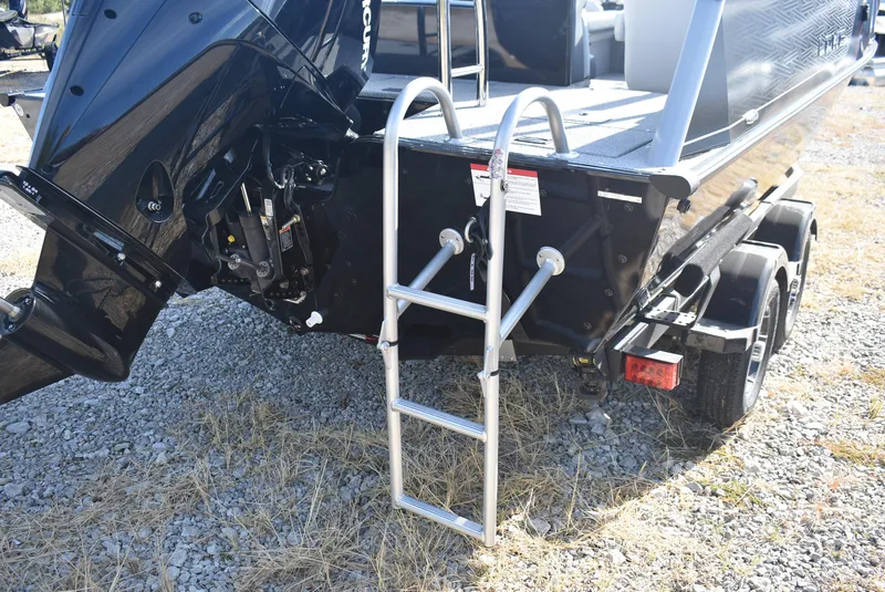 Slide: The Image of 2025 Lowe SD224 Sport Deck boat with ladder and trailer on gravel. - 6