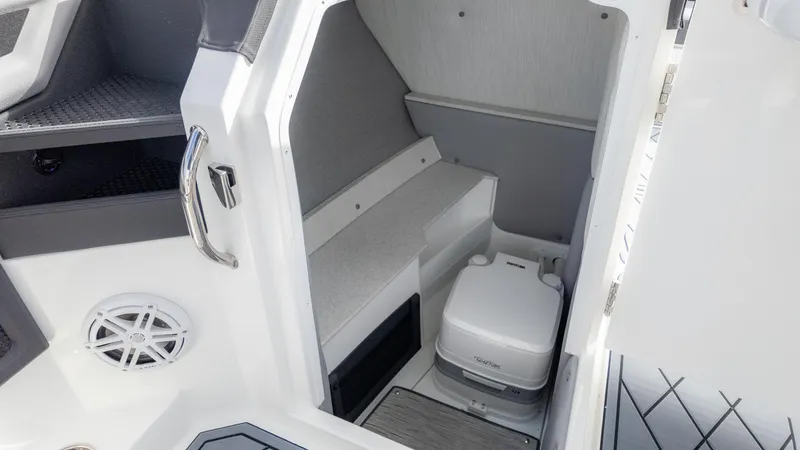 Slide: The Image of 2025 Cobalt R6 Outboard boat interior with compact toilet and storage area. - 23
