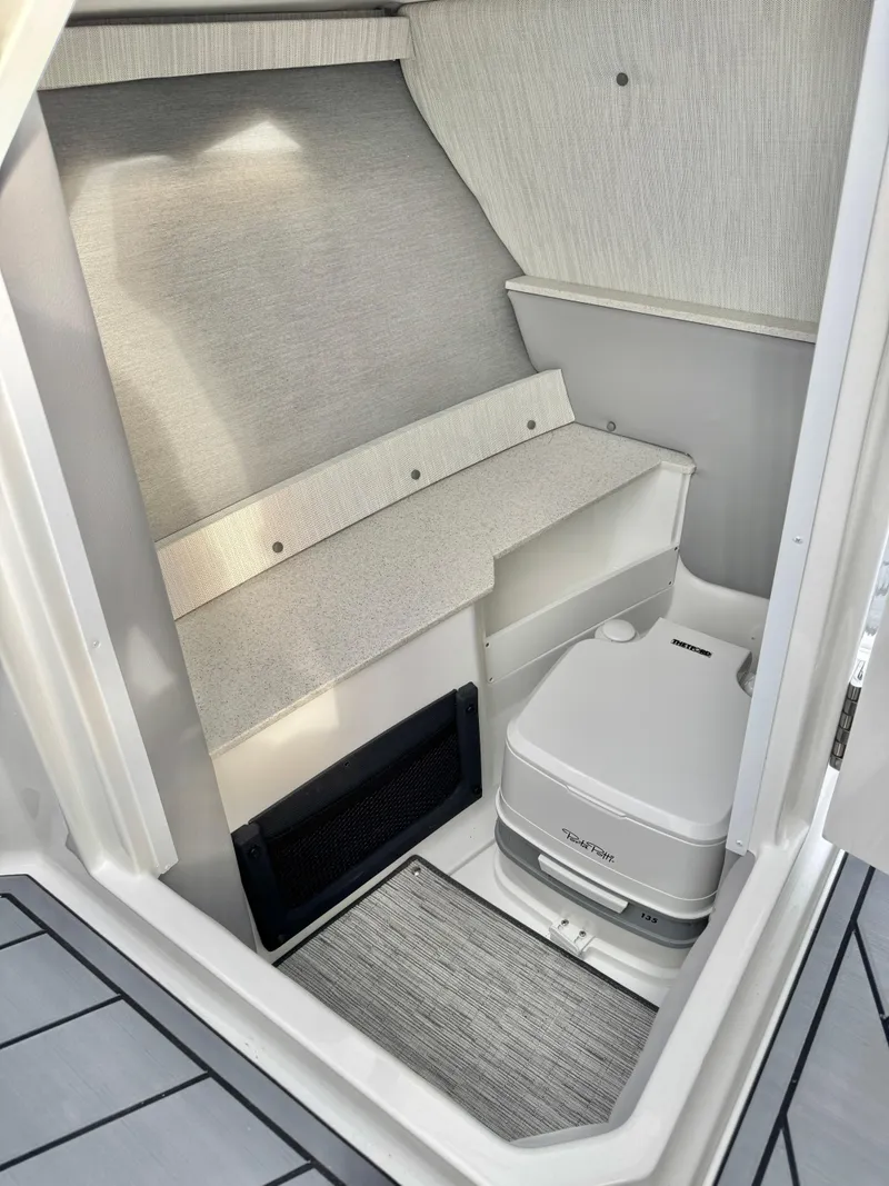 Slide: The Image of 2025 Cobalt R6 Outboard interior cabin with compact toilet and modern design. - 24