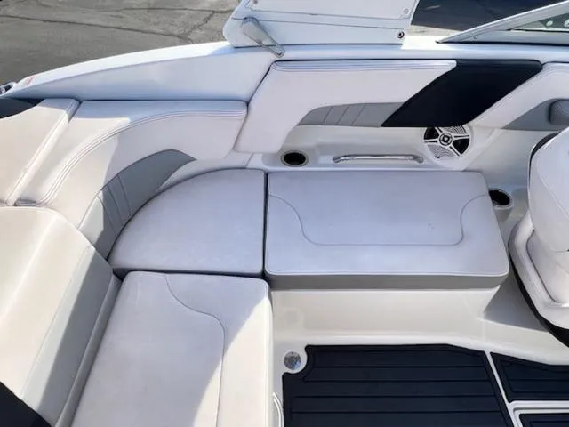 Slide: The Image of 2019 Chaparral 23 H2O Surf boat interior with cushioned seating and speaker. - 13