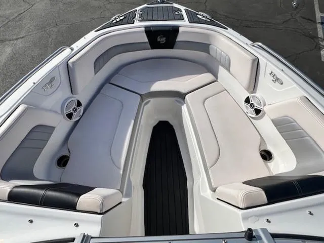 Slide: The Image of 2019 Chaparral 23 H2O Surf boat interior with cushioned seating and speakers. - 16