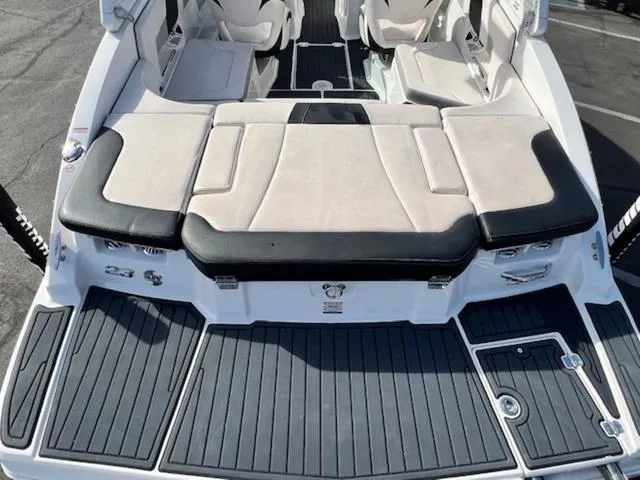 Slide: The Image of 2019 Chaparral 23 H2O Surf boat, rear view with cushioned seating and swim platform. - 9