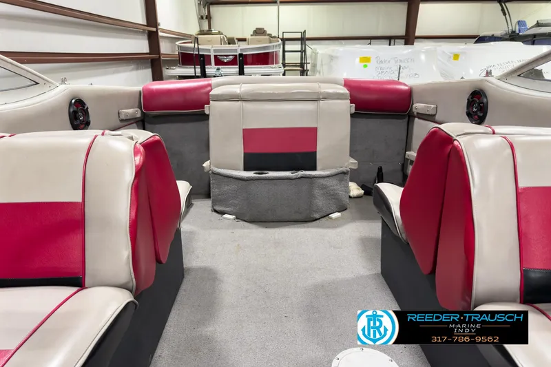 Slide: The Image of 1993 Bryant 200 boat interior with red and gray seating in a storage facility. - 12