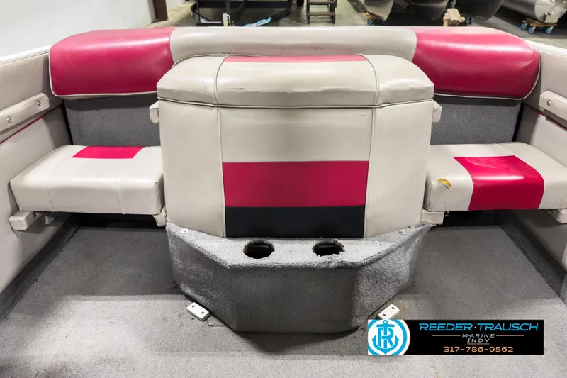 Slide: The Image of 1993 Bryant 200 boat interior with red and gray seating, featuring cup holders. - 13