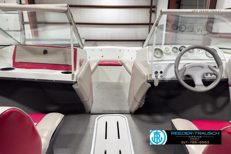 Slide: The Image of 1993 Bryant 200 boat interior with red and white seating, steering wheel, and dashboard. - 14