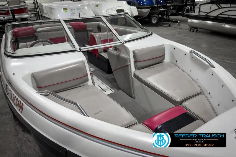 Slide: The Image of 1993 Bryant 200 boat interior with white and red seating, displayed in a showroom. - 16