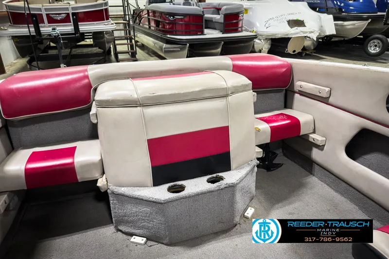 Slide: The Image of 1993 Bryant 200 boat interior with red and beige seating, cup holders, and showroom display. - 27