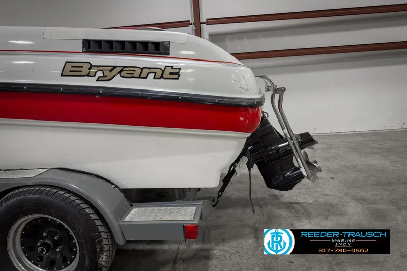 Slide: The Image of 1993 Bryant 200 boat with red stripe, displayed in a showroom. - 33