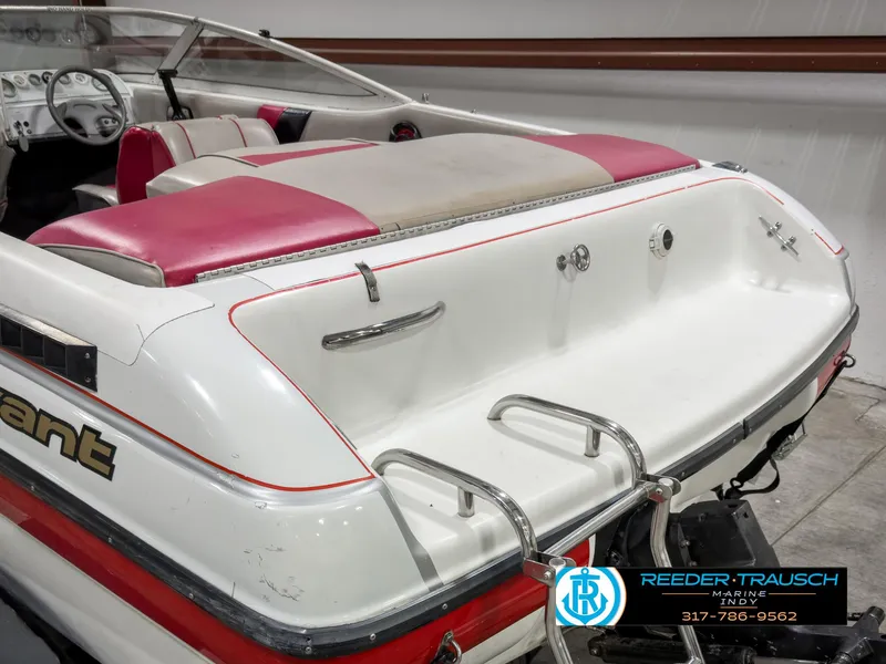 Slide: The Image of 1993 Bryant 200 boat with red and white seating, rear view, in showroom. - 37