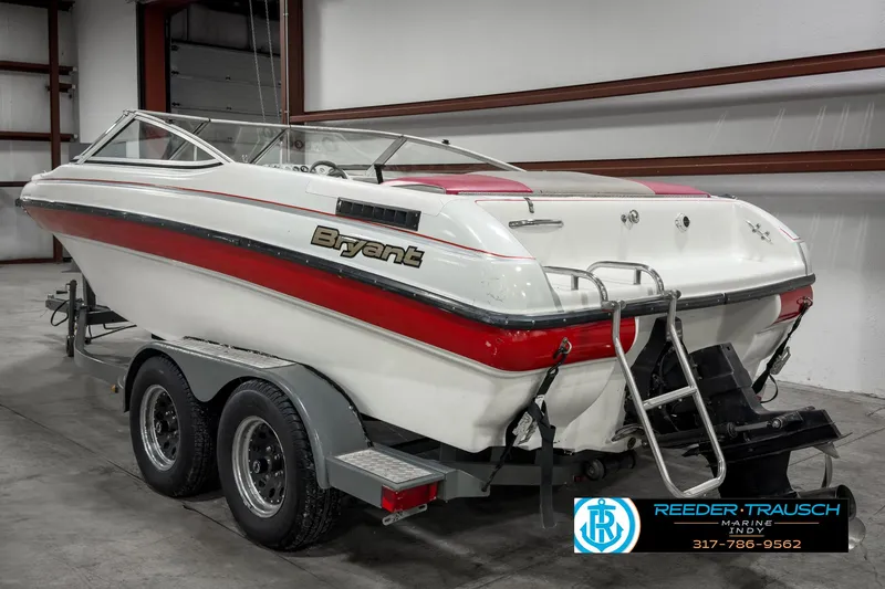 Slide: The Image of 1993 Bryant 200 boat with red stripe on trailer in warehouse. - 4