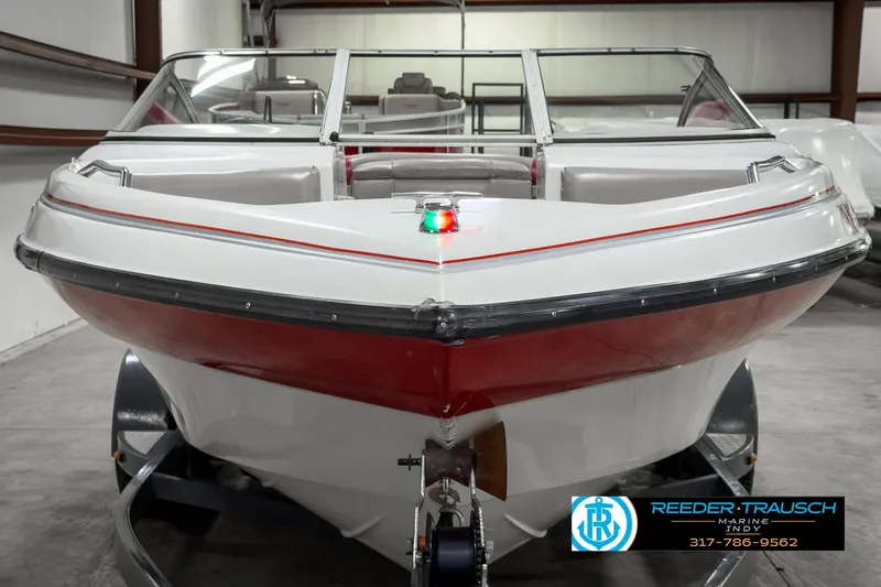 Slide: The Image of 1993 Bryant 200 boat in showroom, red and white design, front view. - 6